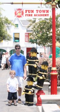 John and Mark standing by 3 lego firemen
