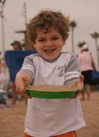 Mark holding sand pie at beach